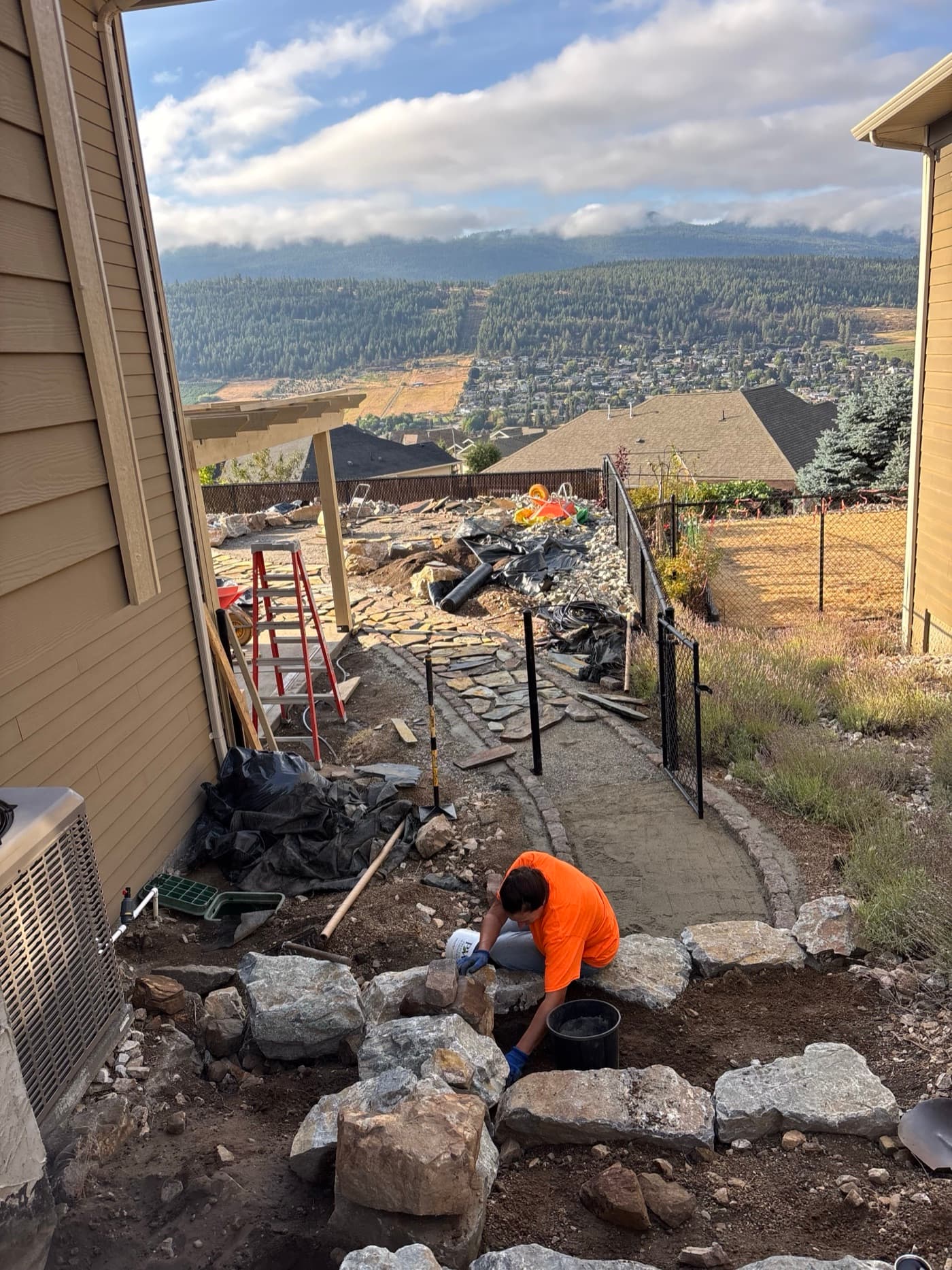 Brink crew setting boulders on a hillside hardscape in Vernon